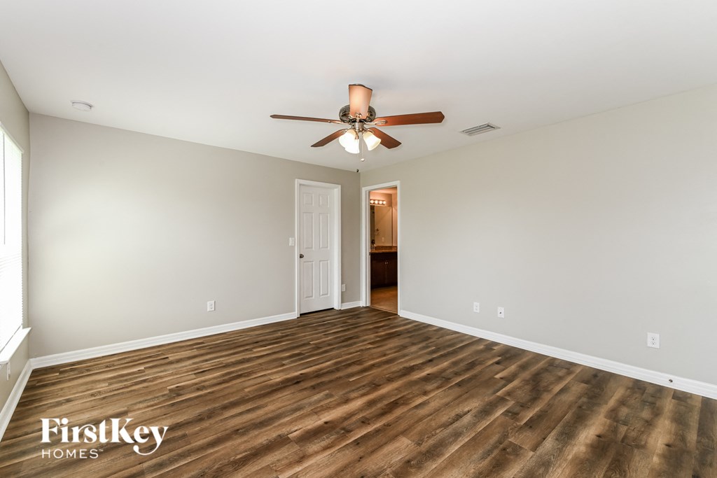 a living room with wood flooring and a ceiling fan