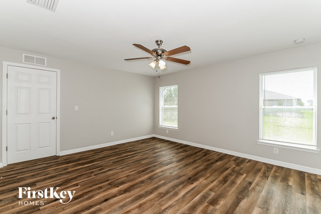 a living room with wood floors and a ceiling fan