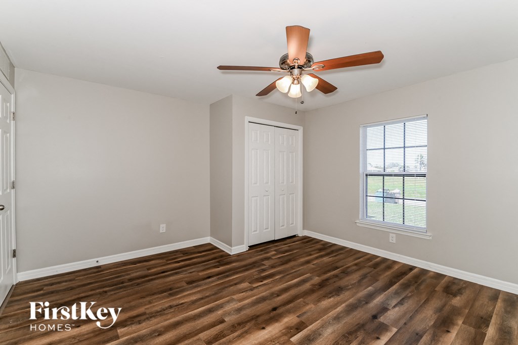 a living room with wood flooring and a ceiling fan
