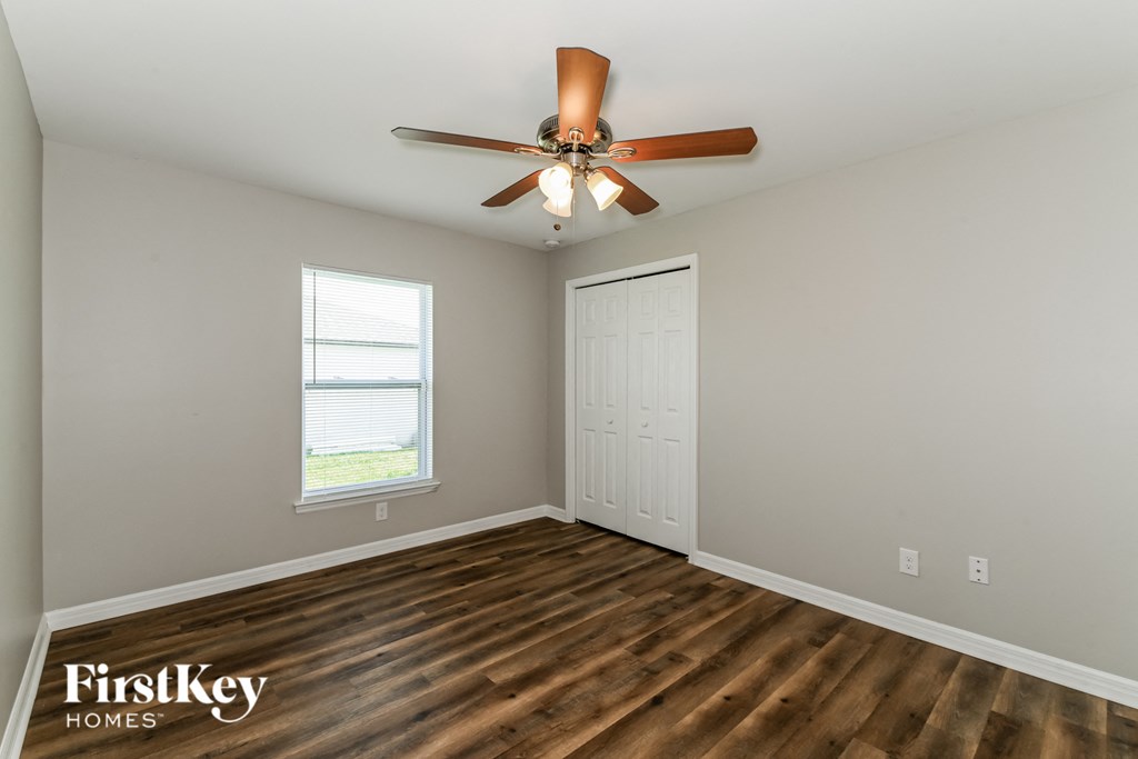 a living room with wood flooring and a ceiling fan