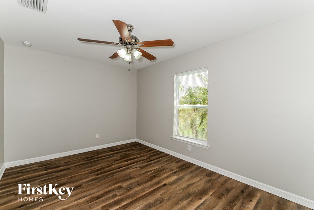 a bedroom with a ceiling fan and a window