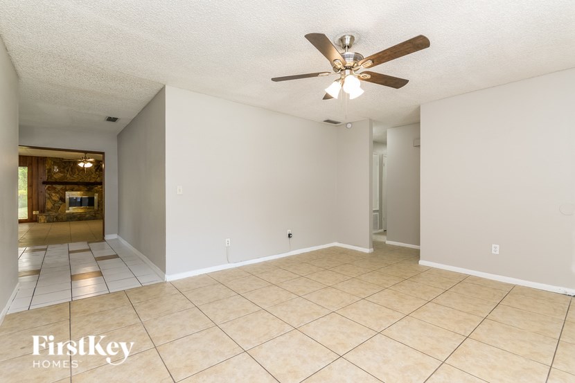 A spacious room with a ceiling fan and tiled floor.