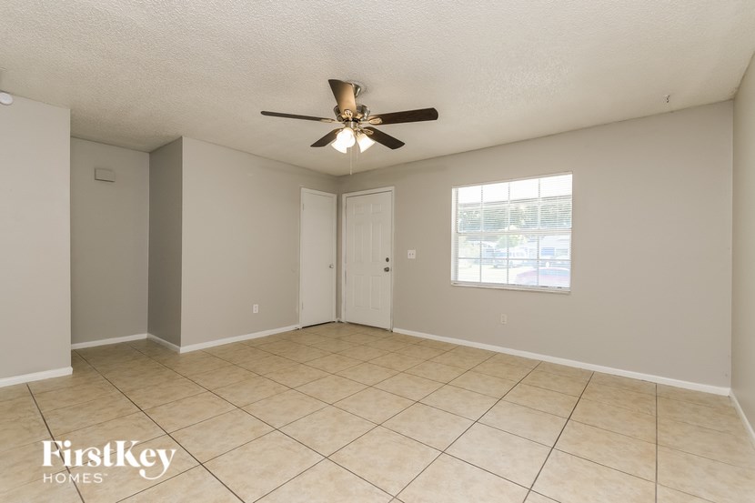 A spacious room with a ceiling fan and a window.