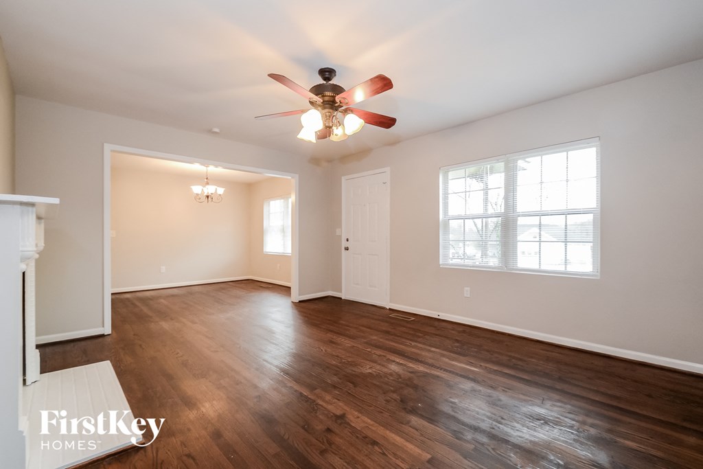 the living room of an empty house with a ceiling fan