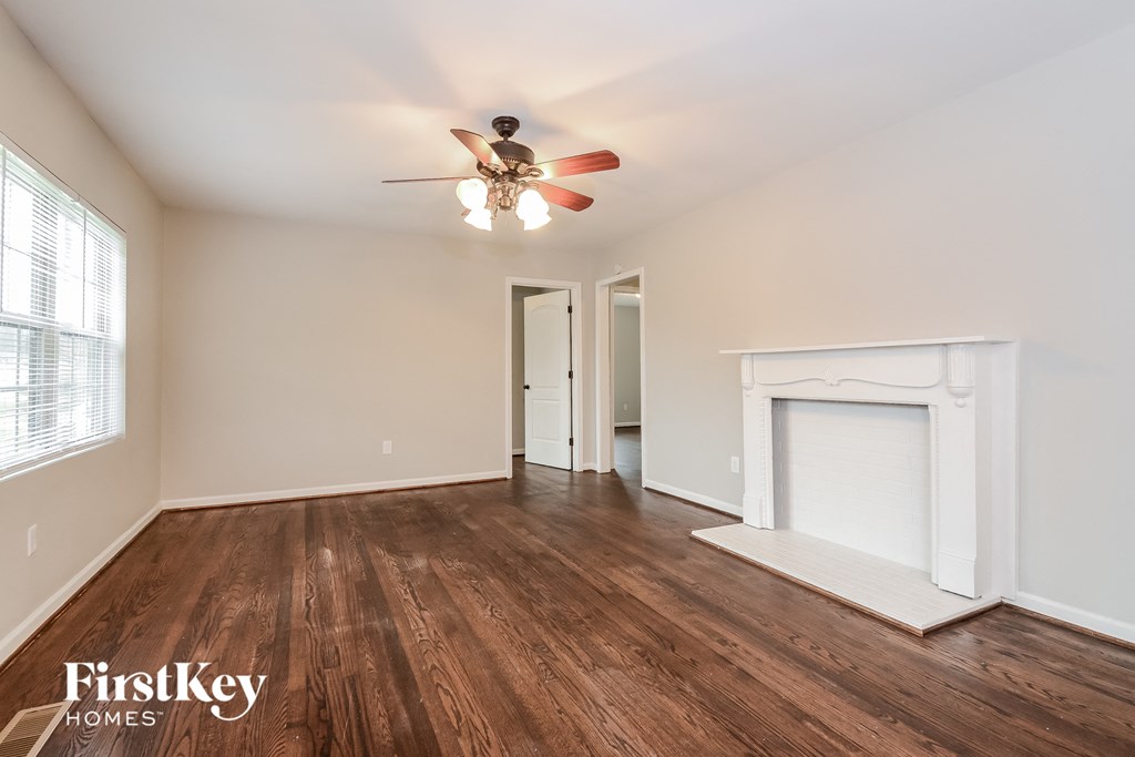 a living room with a ceiling fan and a fireplace
