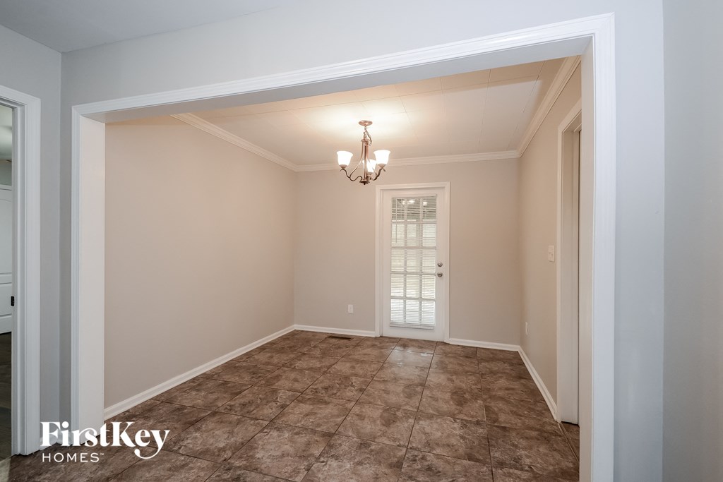 a empty dining room with a door and a chandelier
