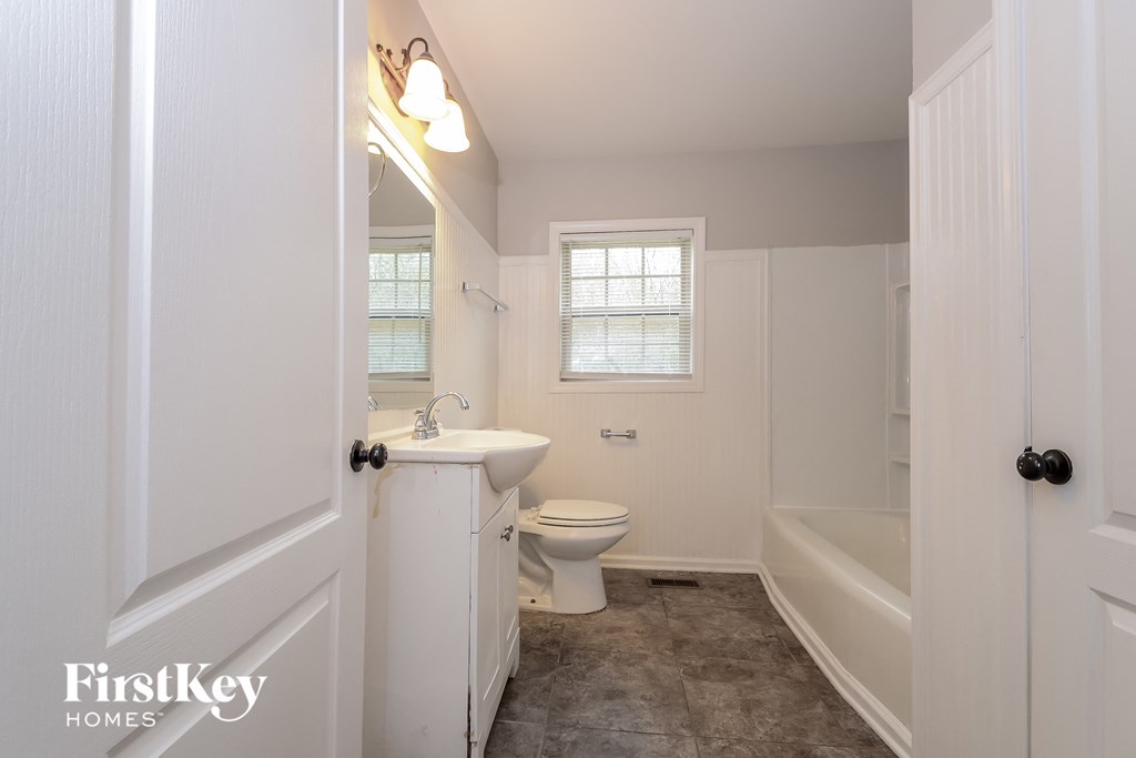a bathroom with a toilet and a sink and a bath tub