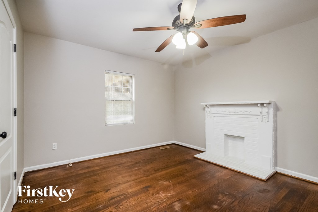 a living room with a fireplace and a ceiling fan