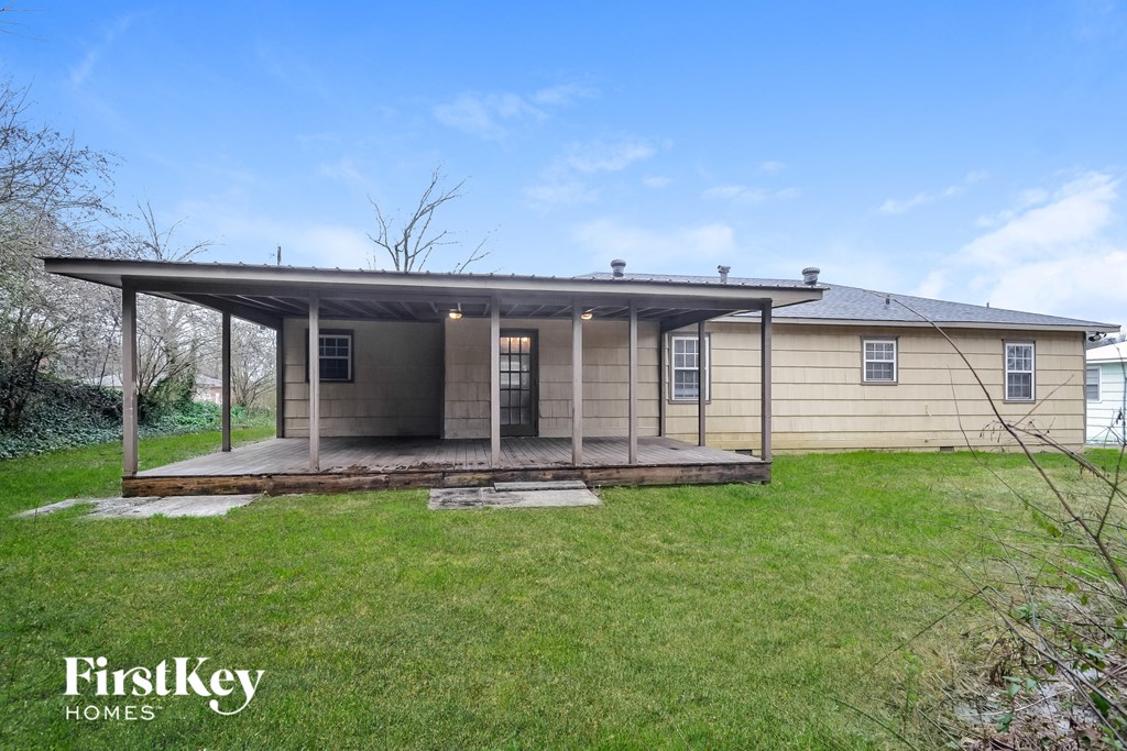 a small house with a covered porch in a grassy yard