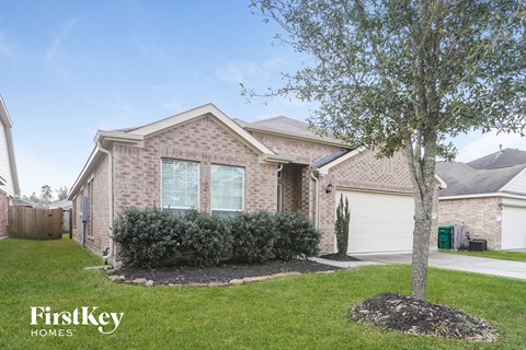 a brick house with a tree in the front yard