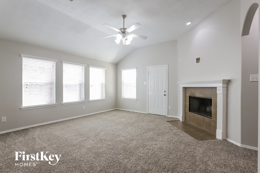 a living room with a fireplace and a ceiling fan