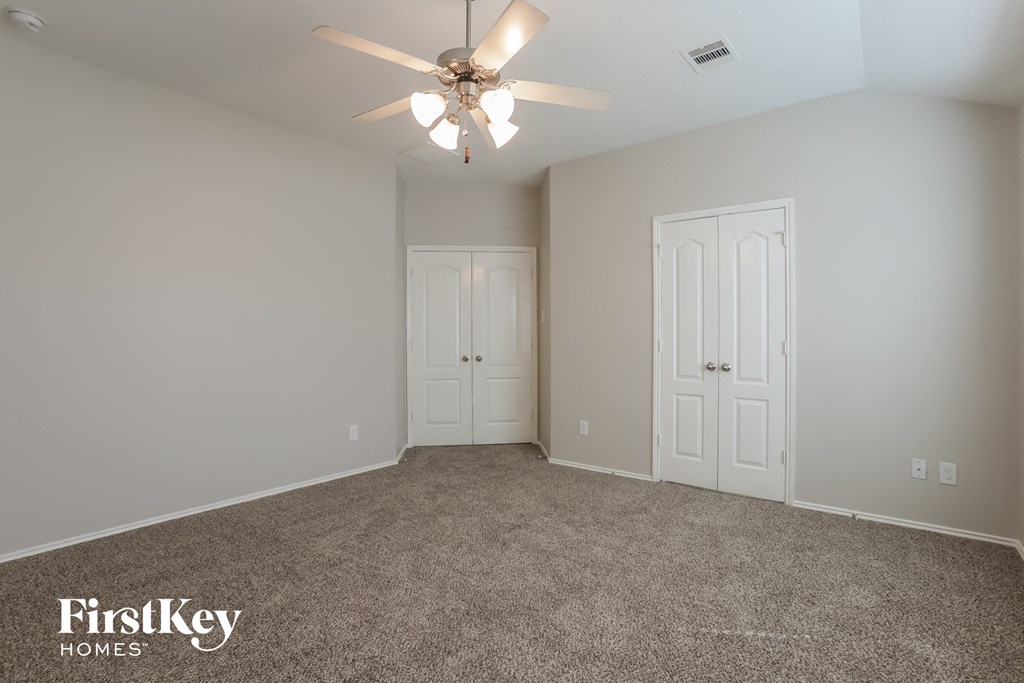 a bedroom with carpet and a ceiling fan