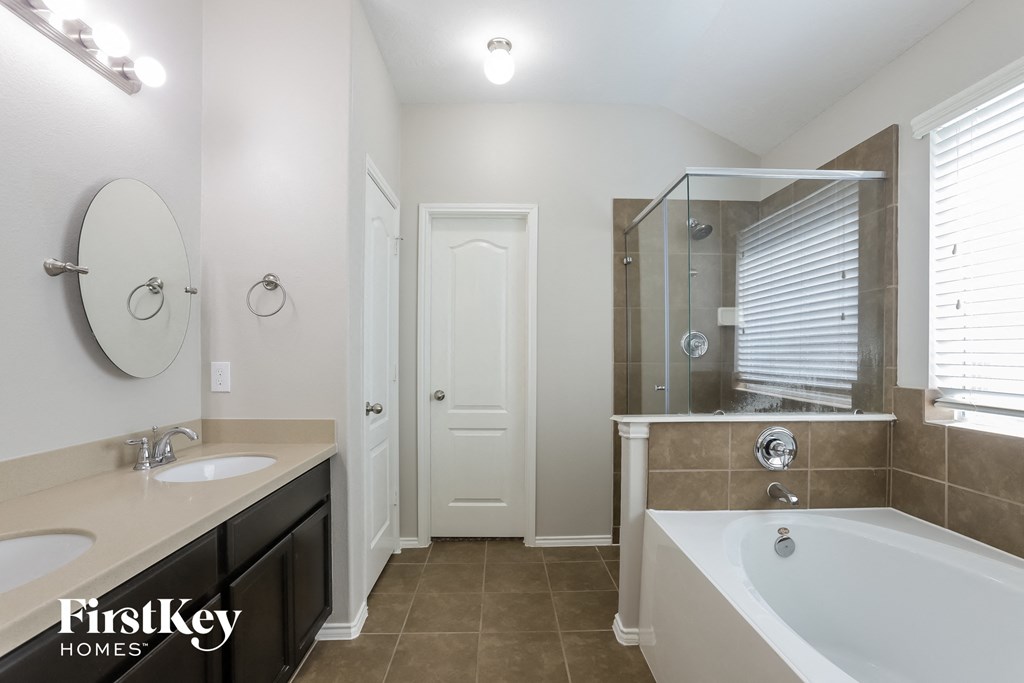 a bathroom with a large tub and a sink and a shower