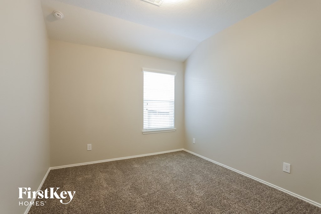 an empty room with carpet and a window