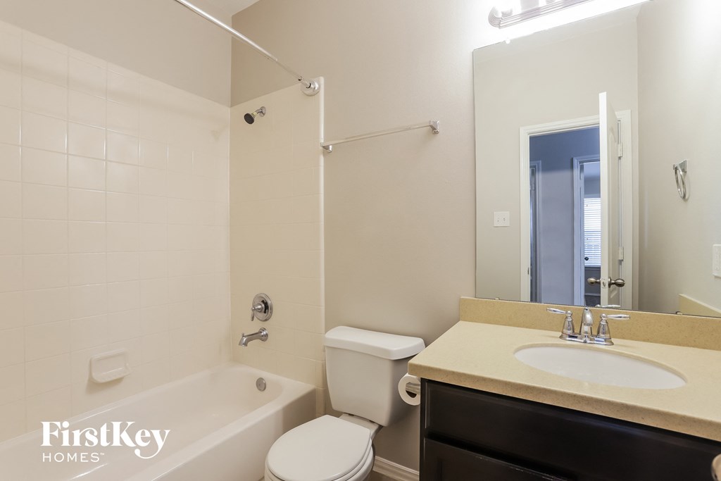 a bathroom with a sink toilet and tub and a mirror