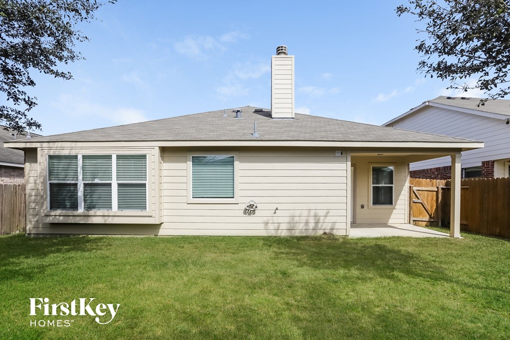the front of a white house with a lawn and a fence