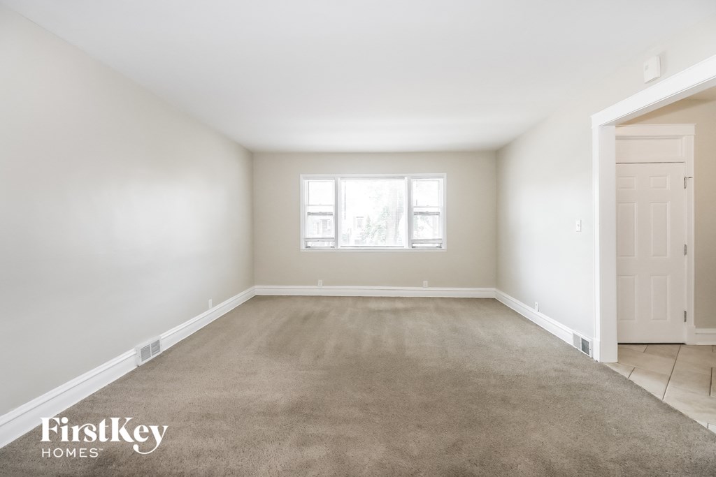 a empty room with a carpeted floor and a window