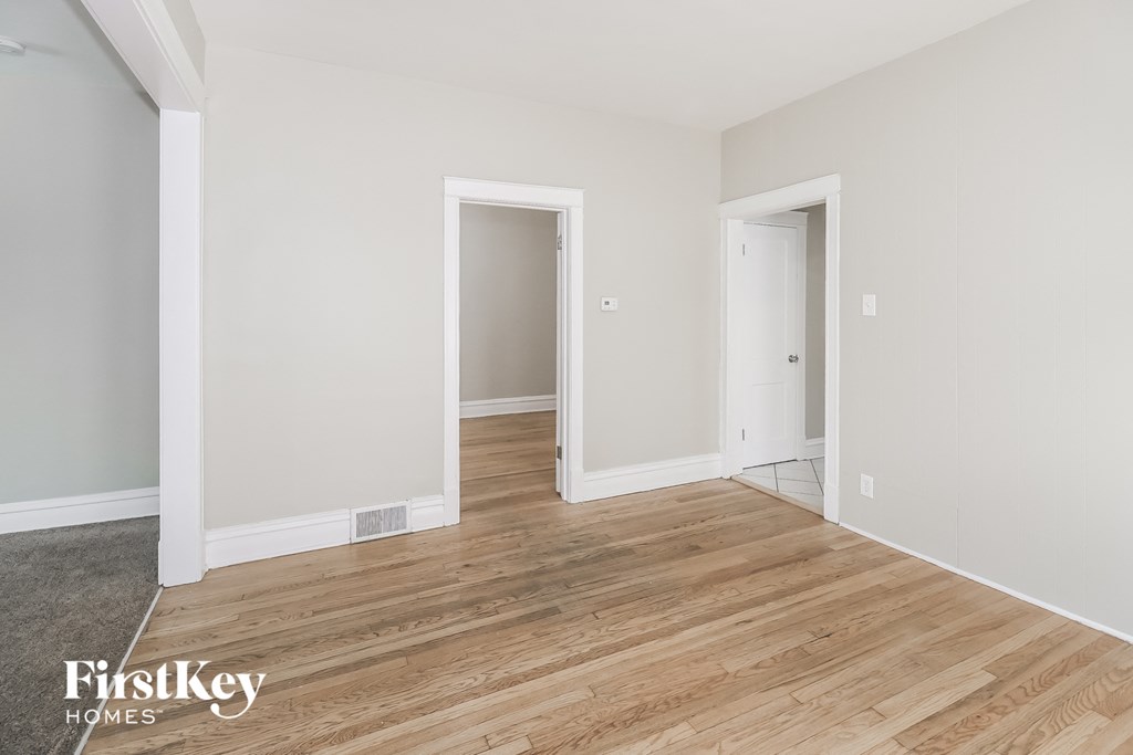 a living room with white walls and wood floors
