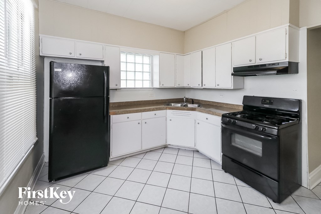 a white kitchen with black appliances and white cabinets