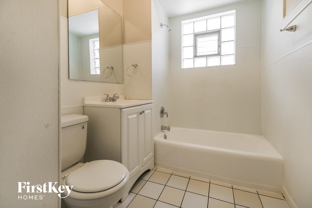 a bathroom with a toilet and a tub and a sink