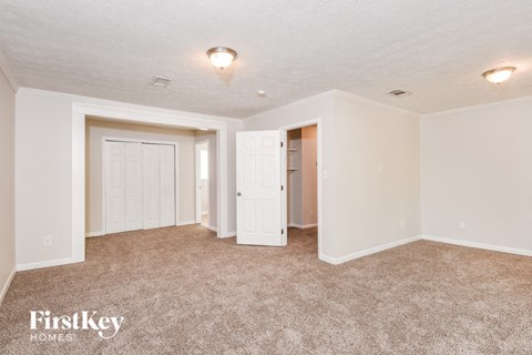 A carpeted room with a FirstKey Homes logo.