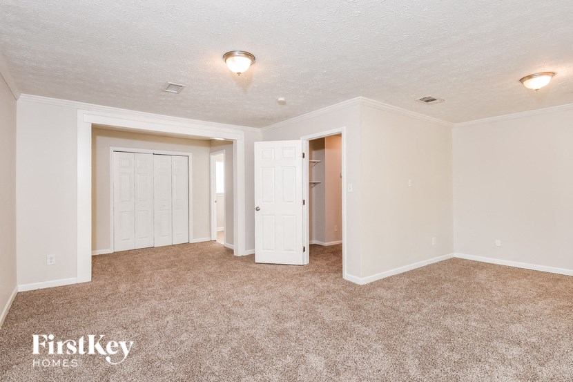 A carpeted room with a FirstKey Homes logo.