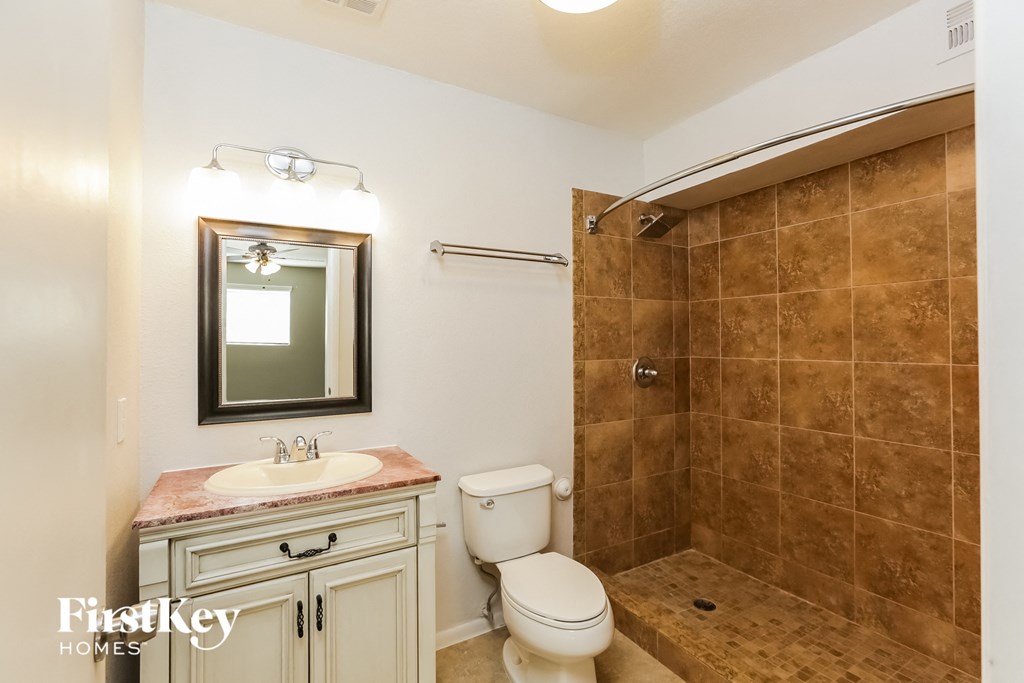 a bathroom with a shower and a sink and a toilet