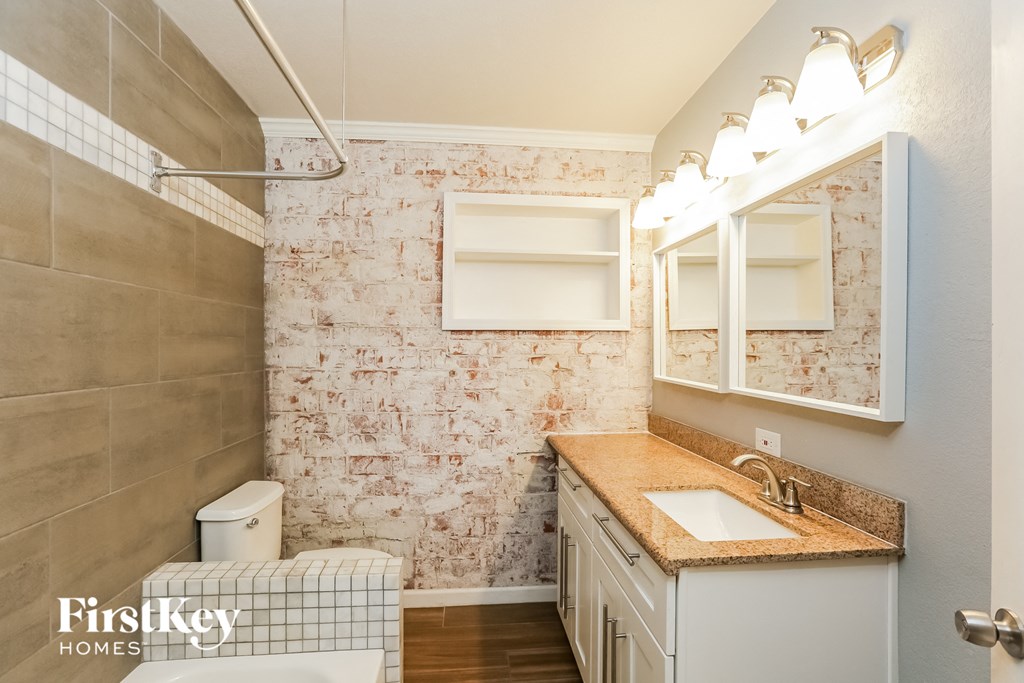 a bathroom with a toilet and a sink and a mirror