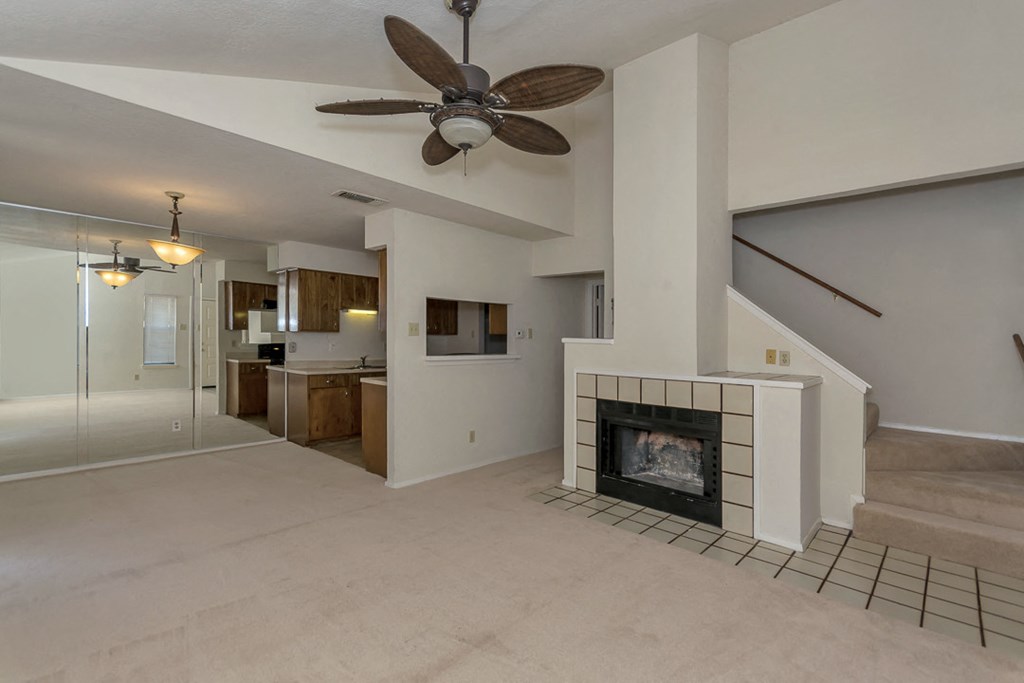 a living room with a fireplace and a ceiling fan