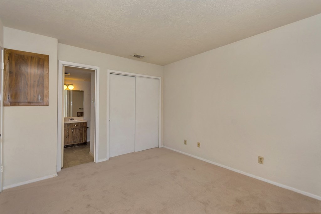 an empty living room with a door to a bathroom