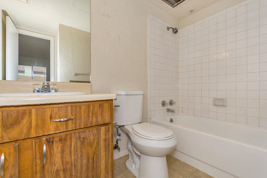 a bathroom with a toilet and a tub and a sink