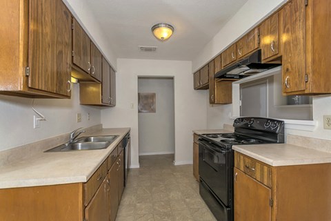 a kitchen with wooden cabinets and a stove and a sink