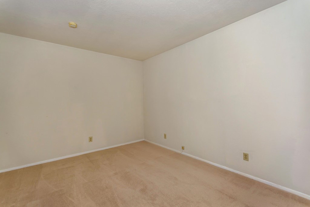 a empty room with white walls and wooden floors