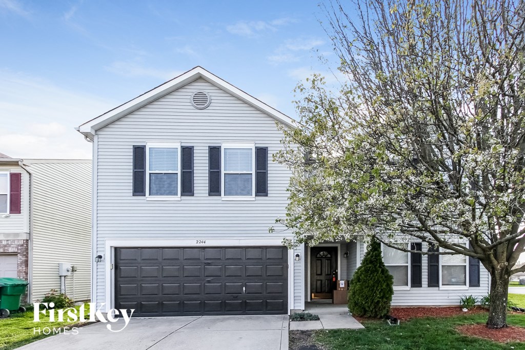 a white house with a black garage door
