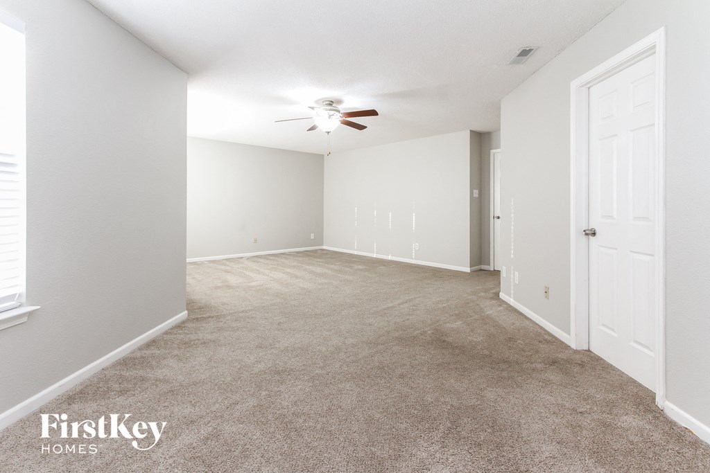 a bedroom with a carpeted floor and a ceiling fan