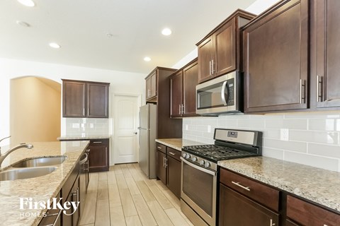 A kitchen with brown cabinets and a black stove top oven.