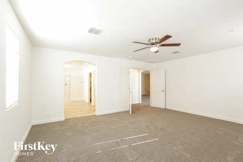 A spacious room with a fan and carpeted floor.