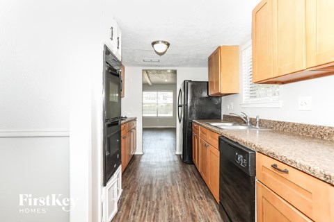 A kitchen with wooden cabinets and black appliances.