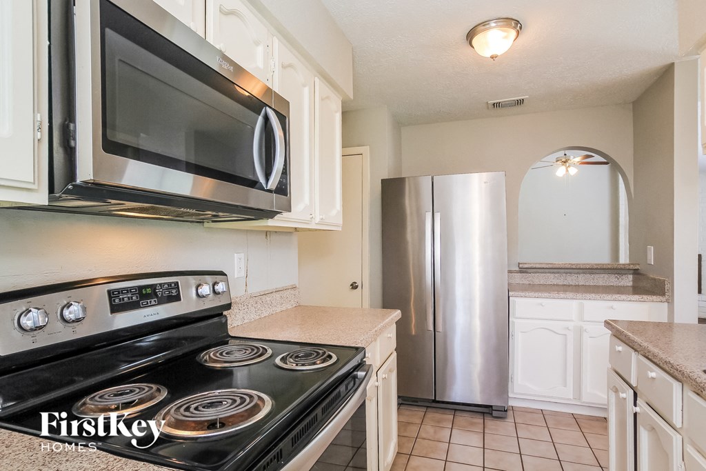 a kitchen with a stove and a microwave and a refrigerator