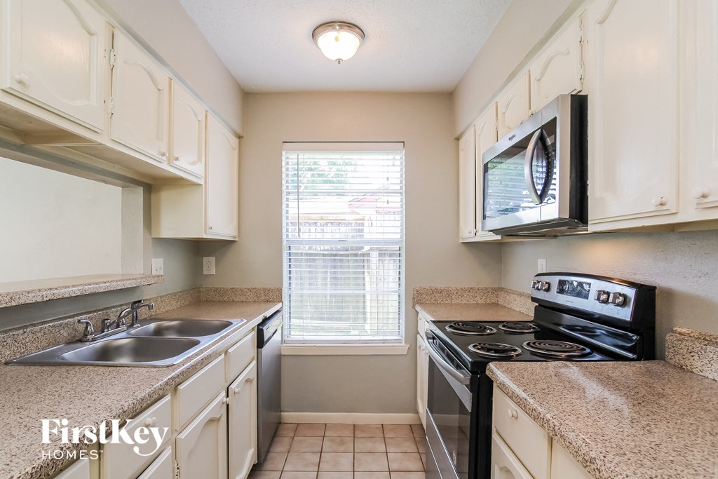 a kitchen with a sink and a stove and a microwave