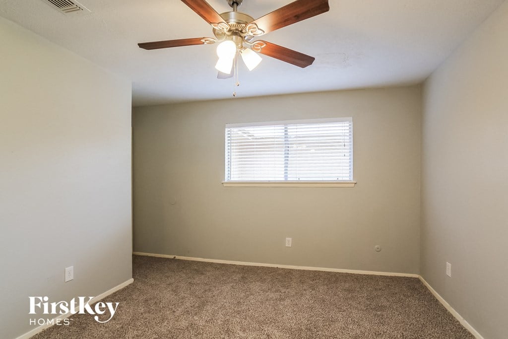 a bedroom with a ceiling fan and a window