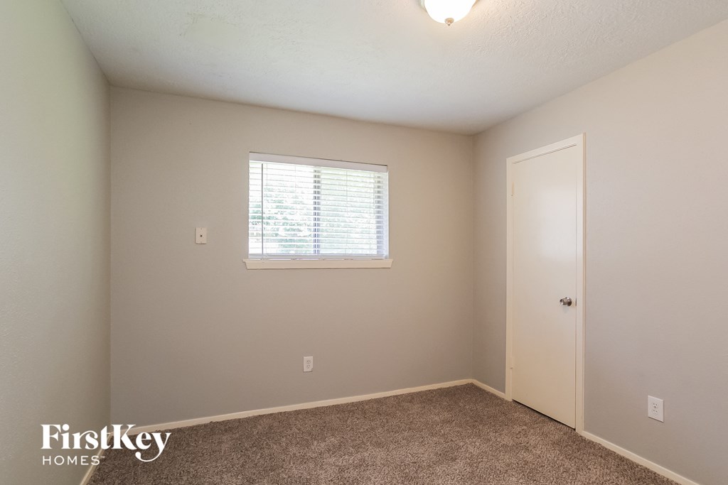 a bedroom with a window and a door