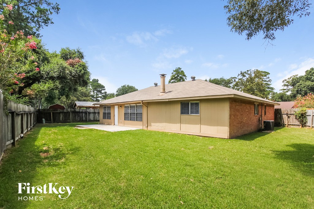 a backyard with a house and a grass yard and a fence