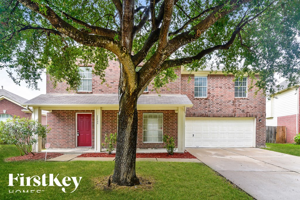 a brick house with a tree in the front