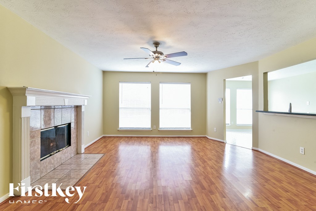 a living room with a fireplace and a ceiling fan