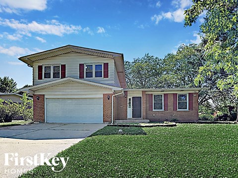 a small brick house with a white garage door