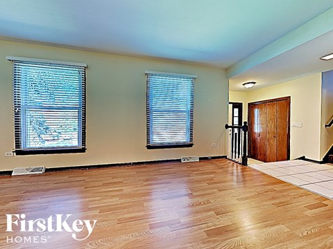 an empty living room with a hard wood floor and windows