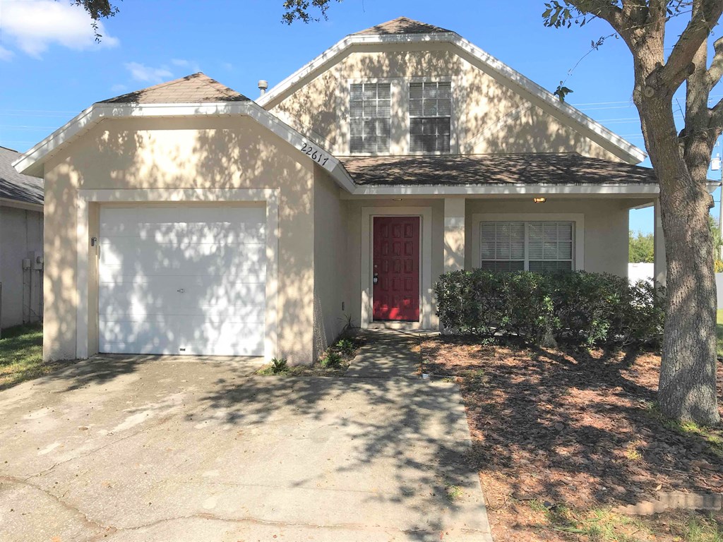 A house with a red door and a white garage door.