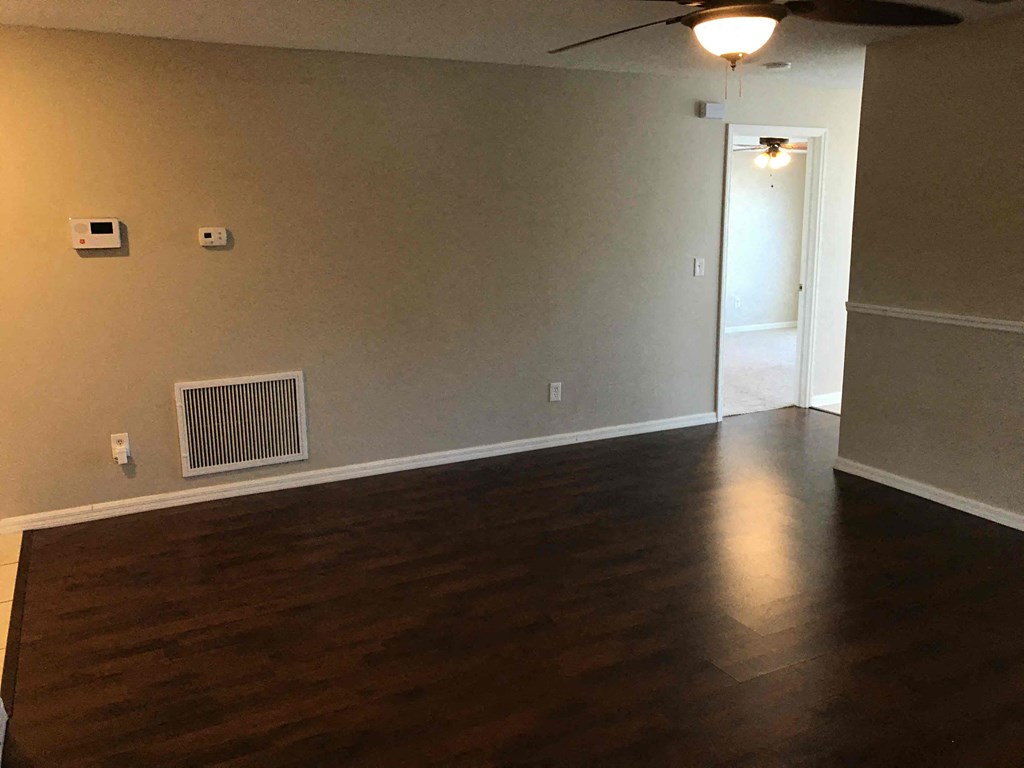 A room with a ceiling fan and a wall-mounted air conditioner unit.