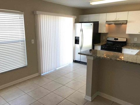 A kitchen with a refrigerator, stove, and oven.